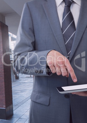 Businessman holding tablet on public street