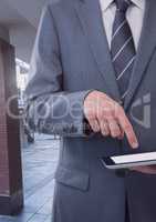 Businessman holding tablet on public street