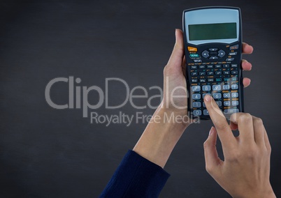 Hands with calculator against navy chalkboard