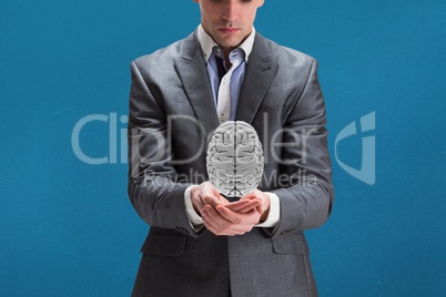 Businessman holding a digital brain in his hands with blue background