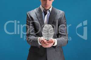 Businessman holding a digital brain in his hands with blue background