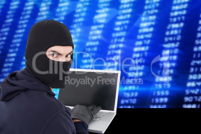 Hacker using a laptop with a blue digital background