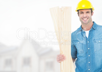 Carpenter with wood on building site