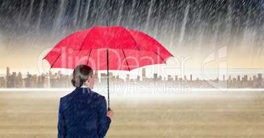 Rear view of businesswoman holding red umbrella standing in digital composite image of rain