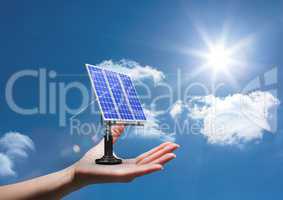 Digital composite image of solar panel on hand against sky