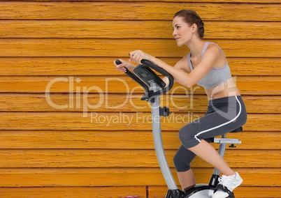 fitness woman with bicycle  with yellow wood background
