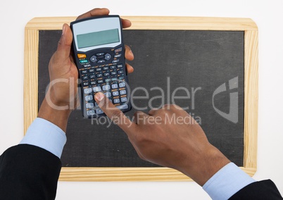 Hands with calculator against chalkboard