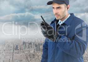 Security guard with walkie talkie against skyline and clouds