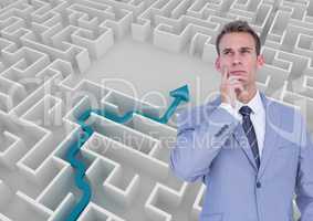 Businessman thinking in front of white background with a blue arrow in a  labyrinth