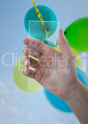 Hand with glass device against sky and balloons