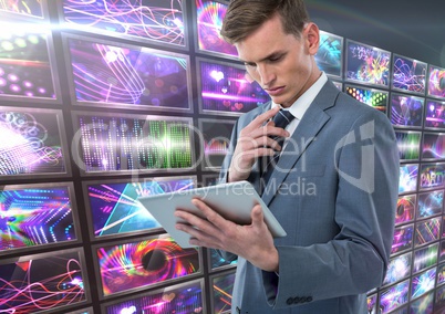 Businessman holding tablet with colorful screens visuals