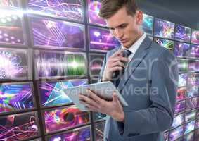 Businessman holding tablet with colorful screens visuals