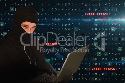 Cyber criminal wearing a hoot is hacking on laptop against matrix code rain background