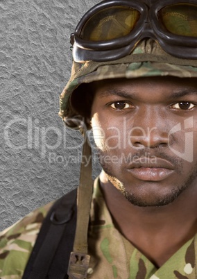 foreground of soldier with helmet (with glasses) looking us. Concrete wall behind