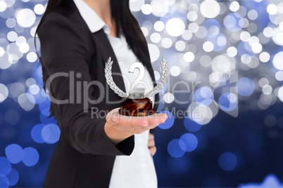 Business woman holding trophy against fireworks background