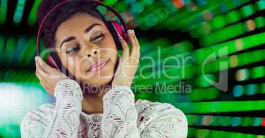 Woman listenning music with headphones with a green background