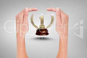 trophy surrounded by hands against grey background