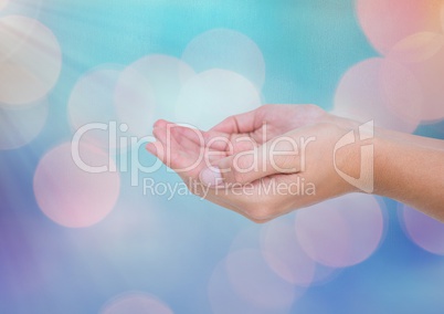 Hands open with sparkling light bokeh background