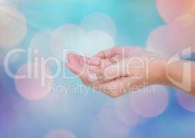 Hands open with sparkling light bokeh background