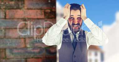 Worried hipster man with his hands on his head in front of a red wall