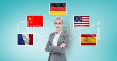 Portrait of businesswoman with arms crossed standing by flags against blue background