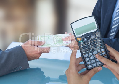 Cropped image of hands using calculator against business people exchanging currencies