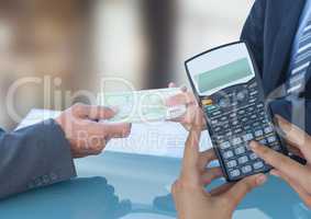 Cropped image of hands using calculator against business people exchanging currencies
