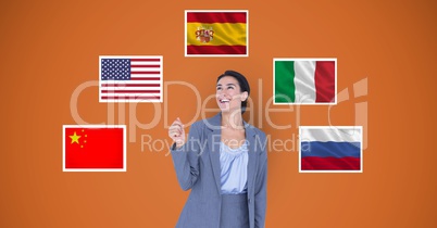 Smiling businesswoman standing by various flags against orange background