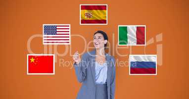 Smiling businesswoman standing by various flags against orange background