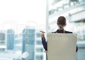 Businesswoman Back Sitting in Chair with cigar and buildings