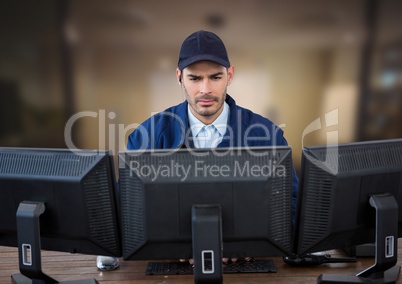 Security guard looking the screens in a blurred office background