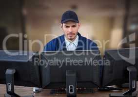 Security guard looking the screens in a blurred office background