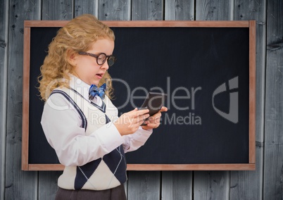 Girl with calculator against chalkboard and grey wood panel