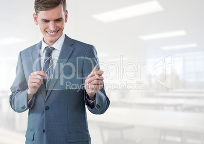 Businessman holding glass tablet in bright workshop factory