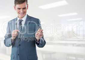 Businessman holding glass tablet in bright workshop factory