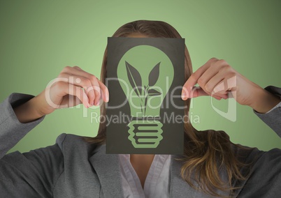 Business woman with black card over face showing green lightbulb graphic against green background