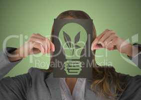 Business woman with black card over face showing green lightbulb graphic against green background