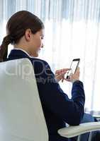 Businesswoman Back Sitting in Chair with mobile phone by window