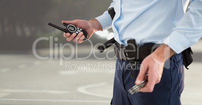 Security guard lower body with walkie talkie against blurry street