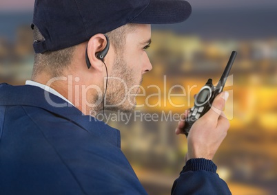 Security guard with headphone and walkie-talkie with a blurred night background