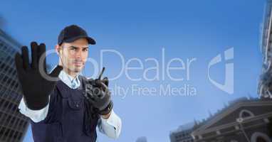 Portrait of security guard showing stop gesture while holding walkie talkie in city
