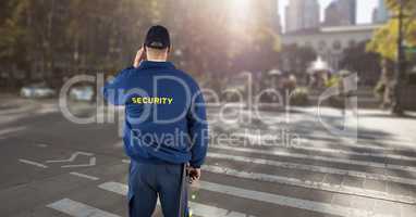Rear view of security guard standing on road in city