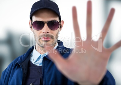 Security guard with headphones saying stop with his hand in a blurred background