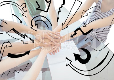 Close up of team at table putting hands together behind arrow graphics