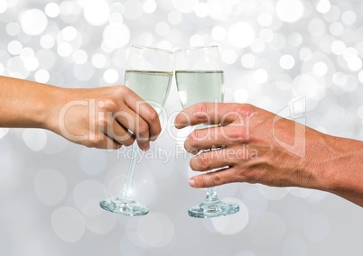 Hands holding champagne with sparkling light bokeh background