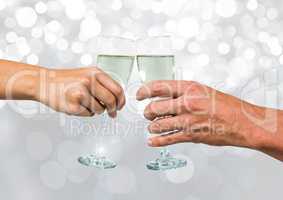Hands holding champagne with sparkling light bokeh background