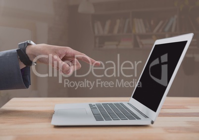 Businessman pointing at laptop with brown background