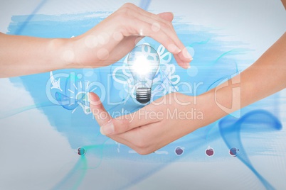 Hands holding bulb against blue background