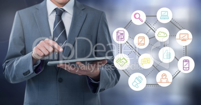 Businessman holding tablet with apps with grey lights background