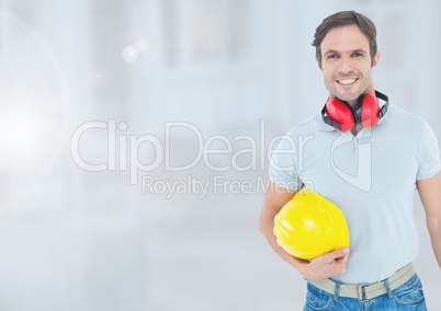 Construction Worker with ear protection in front of construction site